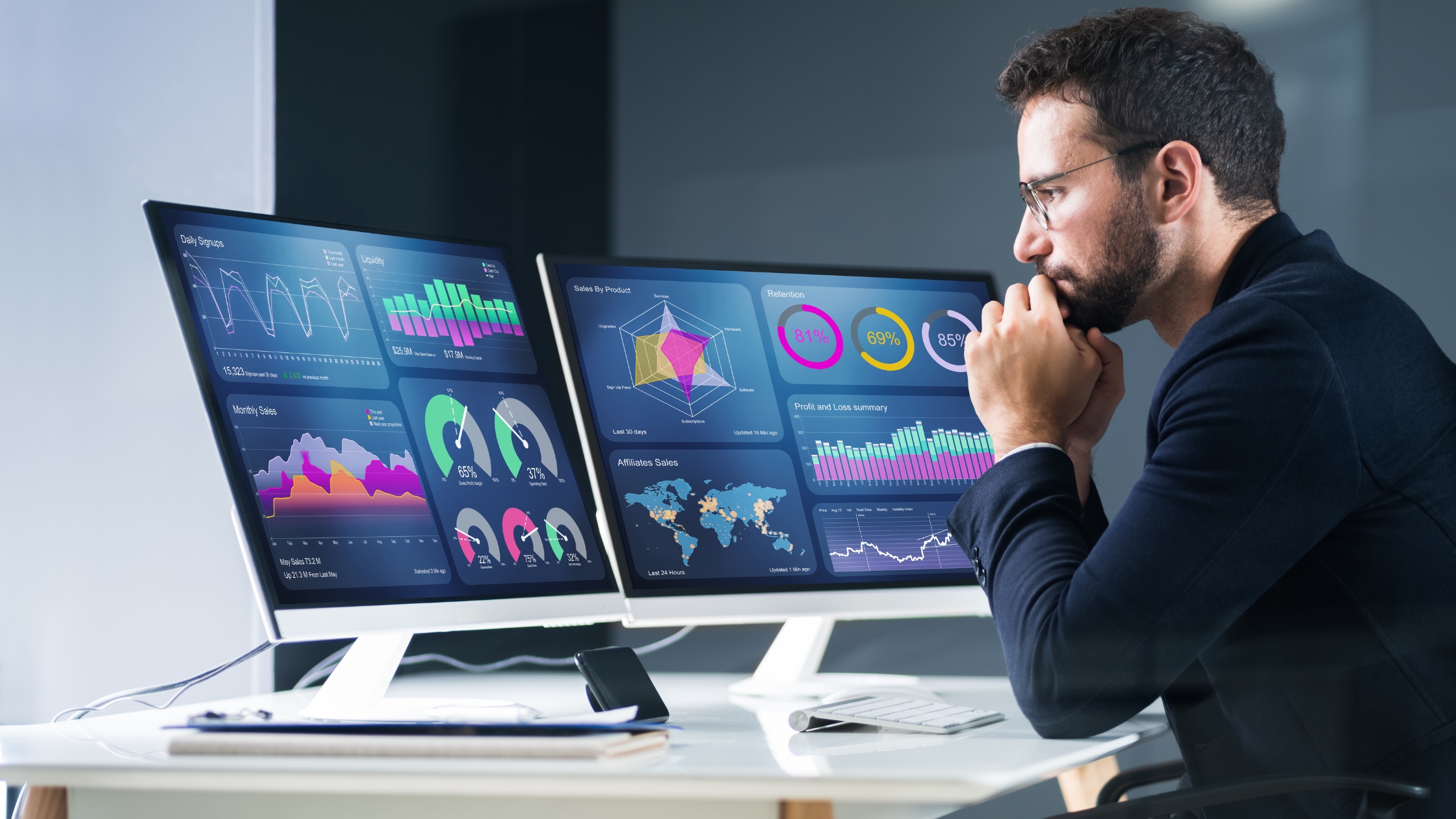 Person analyzing spatial and non spatial data on multiple computer screens in a modern workspace.