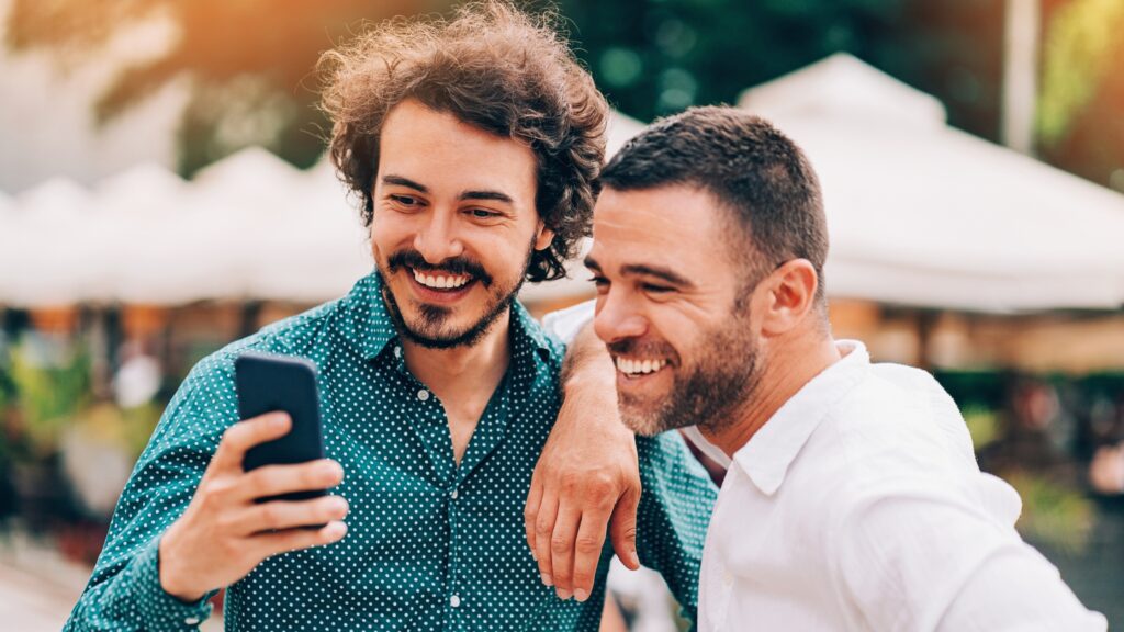 two friends are smiling looking at phone